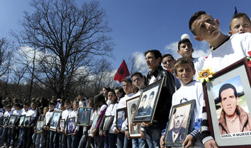 Kosovo Albanian children hold pictures of relatives killed during the Kosovo war, as they mark the 15th anniversary of the massacre in the village of Izbica on March 28, 2014. (AFP file photo)