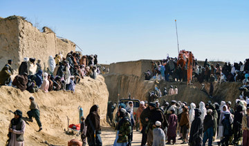 Afghan people gather as rescuers try to reach and rescue a boy trapped for two days down a well in a remote southern Afghan village of Shokak, in Zabul province on Friday. (AFP)