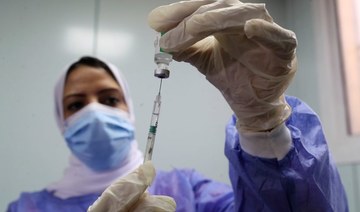 A healthcare worker holds a syringe and vaccine vial against the coronavirus disease (COVID-19) in Cairo last year. (Reuters/File Photo)