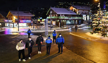 Police officers stand at the centre sqaure of the Swiss Alpine resort of Verbier to prevent people from gathering for the New Year on early January 1, 2021. (AFP)