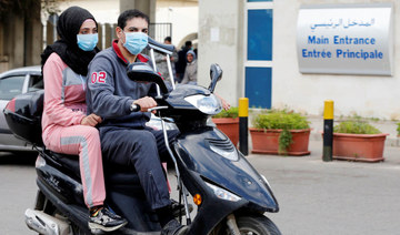People wearing face masks ride on a motorbike outside Rafik Hariri hospital, where Lebanon's first coronavirus case is being quarantined, in Beirut, Lebanon February 21, 2020. (REUTERS)