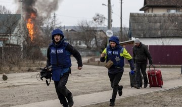 Journalists running for cover in Irpin, Ukraine on March 6, 2022, after heavy Russian shelling. (Reuters)