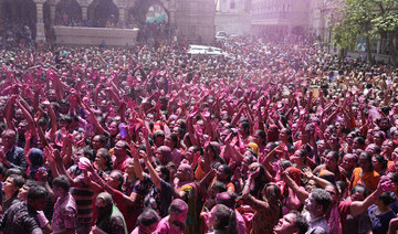 Devotees cheer as colored powder and water are sprayed on them during celebrations marking Holi at the Kalupur Swaminarayan temple in Ahmedabad, India, on Friday. (AP)