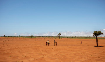 Tarira and her son Avoraza, 4, walk through a field covered with red sand in Anjeky Beanatara, Androy region, Madagascar, February 11, 2022. (REUTERS)