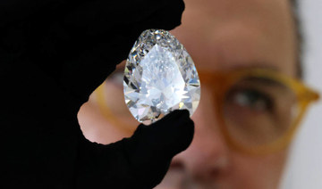 A Christie's auction house staff displays for the media a giant diamond nicknamed "The Rock", in Dubai on March 25 2022, ahead of an auction where it is expected to fetch up to $30 million. (AFP)