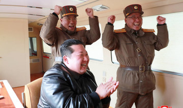 North Korean leader Kim Jong Un reacts next to military officials during  the launch of the 