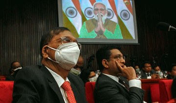 Sri Lanka's Foreign Affairs Minister Gamini Lakshman Peiris, left, listens to a virtual speech by India's Prime Minister Narendra Modi at the fifth Bay of Bengal Initiative for Multi-Sectoral Technical and Economic Cooperation leader's summit. AFP)