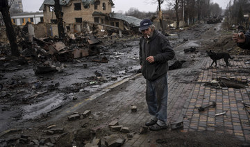 Konstyantyn, 70, smokes a cigarette amid destroyed Russian tanks in Bucha, in the outskirts of Kyiv, Ukraine. (AP)