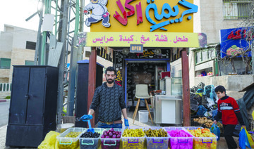 A Palestinian vendor displays a variety of pickles in front of his cafeteria with name in Arabic that reads ‘food crime,’ in the West Bank city of Ramallah. (AP)