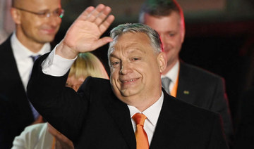 Hungarian Prime Minister Viktor Orban and members of the Fidesz party celebrate on stage at their election base, 'Balna' building on the bank of the Danube River of Budapest, on April 3, 2022. (AFP)