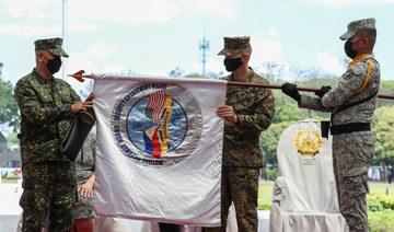 Philippine Balikatan Exercise Director Maj. Gen. Charlton Sean Gaerlan (L) and US Exercise Director Maj. Gen. Jay Bargeron (2nd R) unfurl the Balikatan flag during the opening ceremony for a 12-day joint military drill in Manila on March 28, 2022. (AFP)