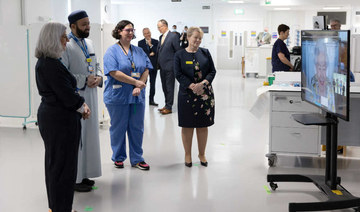 Staff at The Royal London Hospital in east London during a video call with Britain's Queen Elizabeth II, in residence at Windsor Castle, to mark the official opening of the hospital's Queen Elizabeth Unit. (AFP)