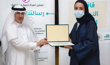Thikra Al-Abdul Latif, director of the Food Empowerment Convoy 2022 project, receives a certificate of thanks from Abdul Wahab Mohammed Al-Faiz after the launch of the project on Sunday in Riyadh. (Supplied)