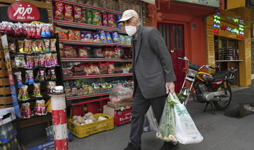 An elderly man carries his shopping in front of a grocery store in Tehran, Iran, Wednesday, May 11, 2022. (AP)
