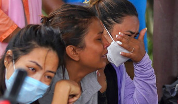 Family members and relatives of passengers on board the Twin Otter aircraft operated by Tara Air, weep outside the airport. 