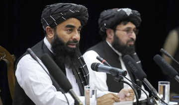 Zabiullah Mujahid, left, the spokesman for the Taliban government, speaks during a press conference in Kabul, Afghanistan