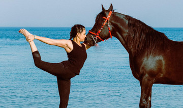 Saudi yoga instructor practices yoga with horses