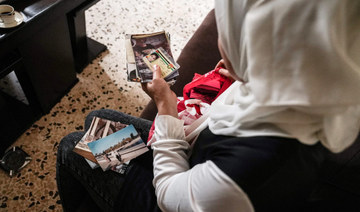 Syrian refugee Ramya al-Sous inspects her family documents at her apartment in Lebanon's Bekaa Valley, on June 13, 2022. (AFP)