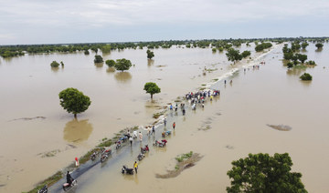 Peole walk through floodwaters after heavy rainfall in Hadeja, Nigeria, Monday, Sept 19, 2022. (AP)