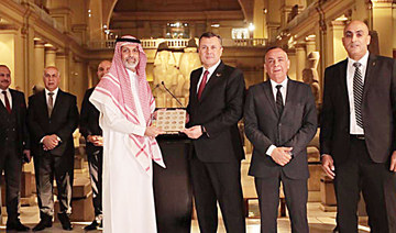 An Egyptian antiquity official hands over coins to a representative from Saudi Arabia in Cairo. (Supplied)