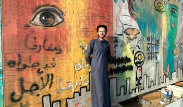 Saudi artist Mohammed  Al-Faraj poses  in front of the ‘Face of the City’ artwork in Hayy Jameel, Jeddah. (Supplied)