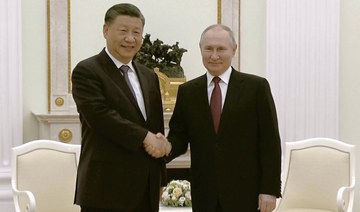 China's President Xi Jinping, left, and Russian President Vladimir Putin shake hands during their meeting in Moscow.