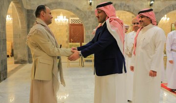 Saudi Arabia’s ambassador to Yemen Mohammed Al-Jaber shakes hands with the political leader of the Houthis, Mahdi Al-Mashat. 