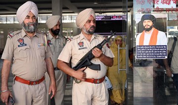 Punjab police stand guard beside Amritpal Singh’s poster at a railway station in Amritsar. (File/AFP)