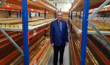The governor of the Central Bank Riad Salameh stands next to stacks of gold bars on shelves at the bank’s headquarters in Beirut
