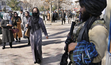Afghan women pass next of Taliban fighter in Kabul, Afghanistan, Feb. 13, 2022. (AP)