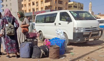 People wait with their luggage at a bus stop in southern Khartoum on May 8, 2023 as fighting continues.