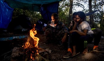 Iraqi migrants sit near a fire waiting to cross into Britain at a makeshift migrants camp in Dunkirk, northern France. (File/AFP