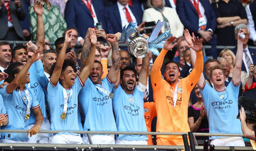 Manchester City’s Ilkay Gundogan lifts the trophy as he celebrates with his teammates after winning the FA Cup. (Reuters)
