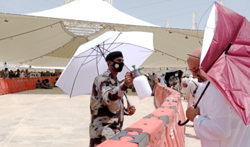 Abdullah Salim of the Special Emergency Force sprays pilgrims with water at the Jamarat complex. (AN photos by Rashid Hassan)