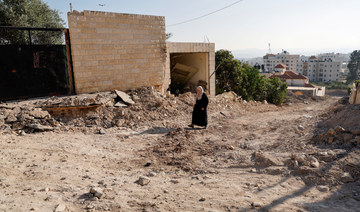 A Palestinian woman walks near her destroyed home, after a two-day Israeli raid in Jenin in the Israeli-occupied West Bank.