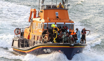 Rescue personnel bring migrants ashore on Saturday. (Reuters)
