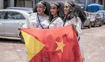 Women pose for a photograph while holding a Tigrayan flag during Ashenda festival in Addis Ababa, Ethiopia, on August 24, 2023. 