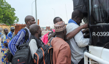 Nigerien nationals board a bus in the border town of Malanville, Benin, to travel to neighboring countries. The junta is resisti