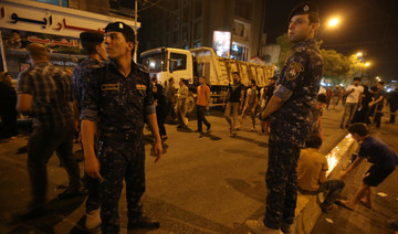 Iraqi security forces keep watch at the site of a suicide car bomb attack which took place early on July 3 in Karrada.