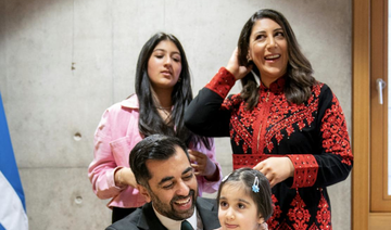 Humza Yousaf (C) is surrounded by his wife Nadia El-Nakla (rear R), his daughter Amal (2nd R), and his step-daughter Maya.