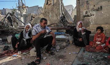 A family drink tea amid the rubble of a building destroyed in Israeli bombing in Rafah in the southern Gaza Strip, on November 7