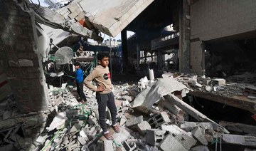 People inspect the damage in the rubble of a mosque following Israeli bombardment, in Rafah, on the southern Gaza Strip.