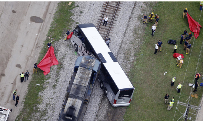 Train hits bus, killing 3; rescuers cut through wreckage