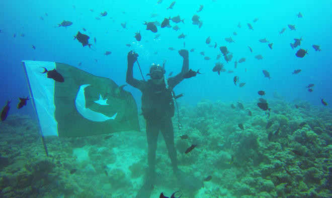 scuba diver with pakistani flag under sea