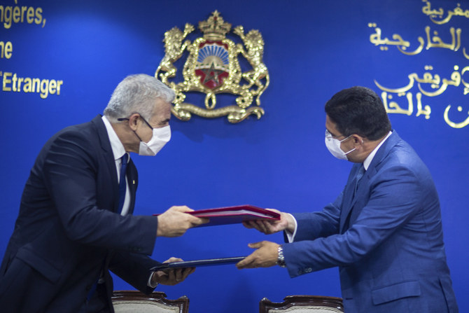 Moroccan Foreign Minister Nasser Bourita, right, and Israeli Foreign Minister Yair Lapid, left, exchange signed cooperation agreements between the two countries, in Rabat, Morocco, Wednesday, Aug. 11, 2021. (AP)