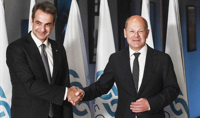 Greek Prime Minister Kyriakos Mitsotakis (L) and German Chancellor Olaf Scholz (R) shake hands during the annual Summit of the South East European Cooperation Process (SEECP) in Thessaloniki on June 10, 2022. (AFP)