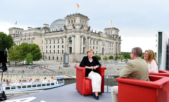 Merkel rejects Muslim migrant ban, urges fair distribution