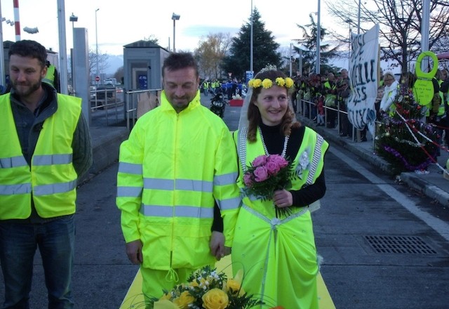 French couple tie knot in yellow-vest themed wedding