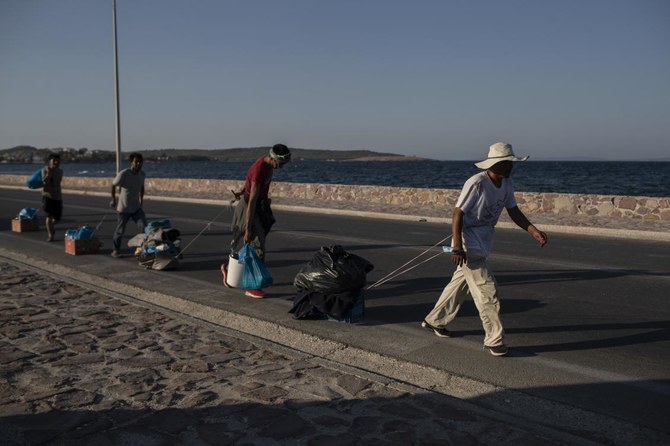 Greek police arrest 5 over Lesbos fire, migrants resist new camp