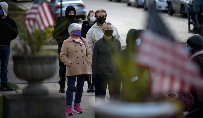 Anxious Americans go to the polls with faces masked, stores boarded up